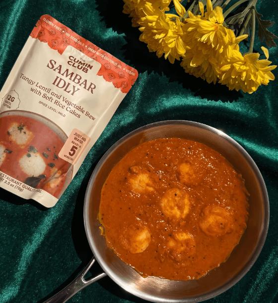 Pan of Sambar Idly with the meal packet and yellow flowers