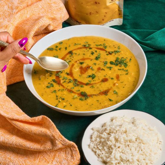 Bowl of Dal Tadka with rice and a spoon